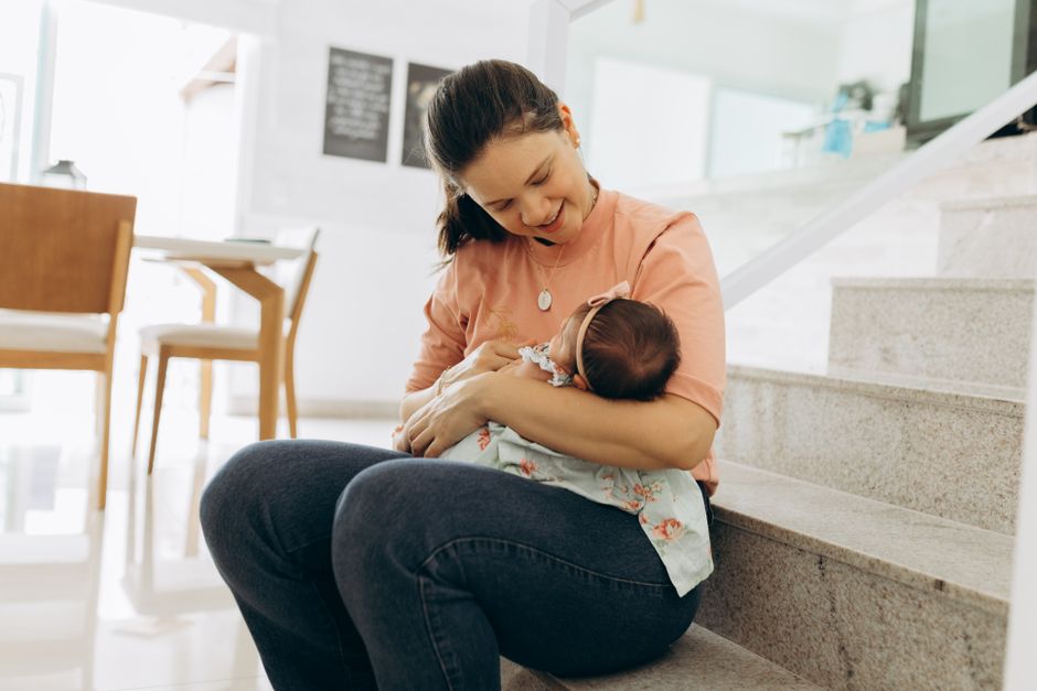 A mother holding her baby at home